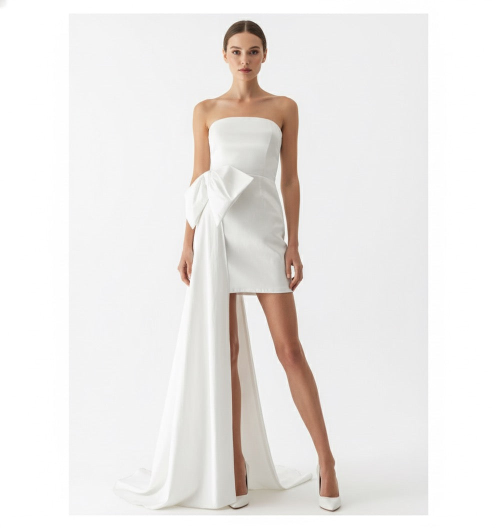 Vestido cauda lateral y moño blanco.